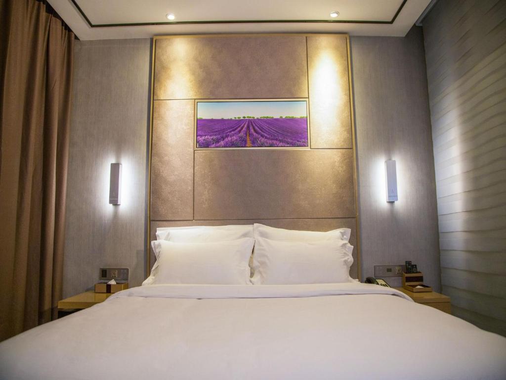 a bedroom with a large bed with white pillows at Lavande Hotel Longnan Changjiang River Avenue in Longnan