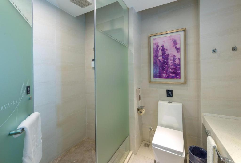 La salle de bains est pourvue de toilettes et d'une douche en verre. dans l'établissement Lavande Hotel Qingyuan Light Rail Station Qingyuan Avenue, à Qingyuan