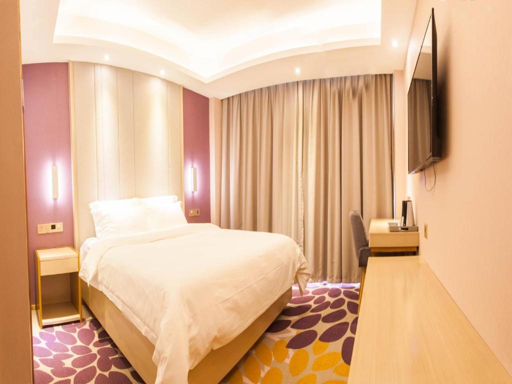 a hotel room with a bed and a flat screen tv at Lavande Hotel Puning International Commodity Mall in Jieyang