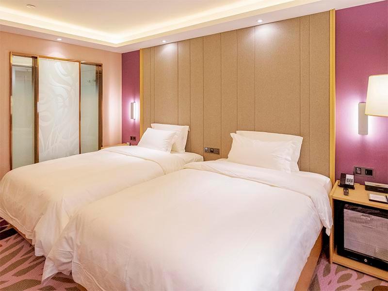 duas camas num quarto de hotel com lençóis brancos em Lavande Hotel Zhengzhou Longhai West Road Subway Station em Zhengzhou