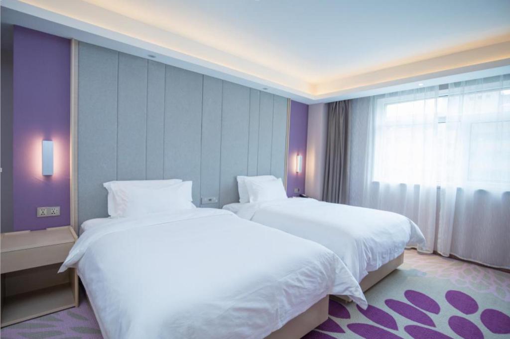 two white beds in a room with a window at Lavande Hotel Lanzhou Chengguan Bridge in Lanzhou