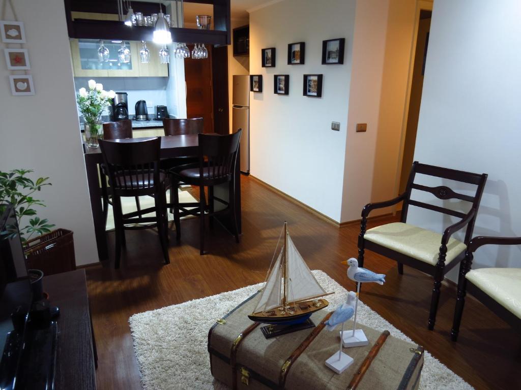 een woonkamer met een tafel en een speelgoedboot op een kofferbak bij Departamento Aquamar in Viña del Mar