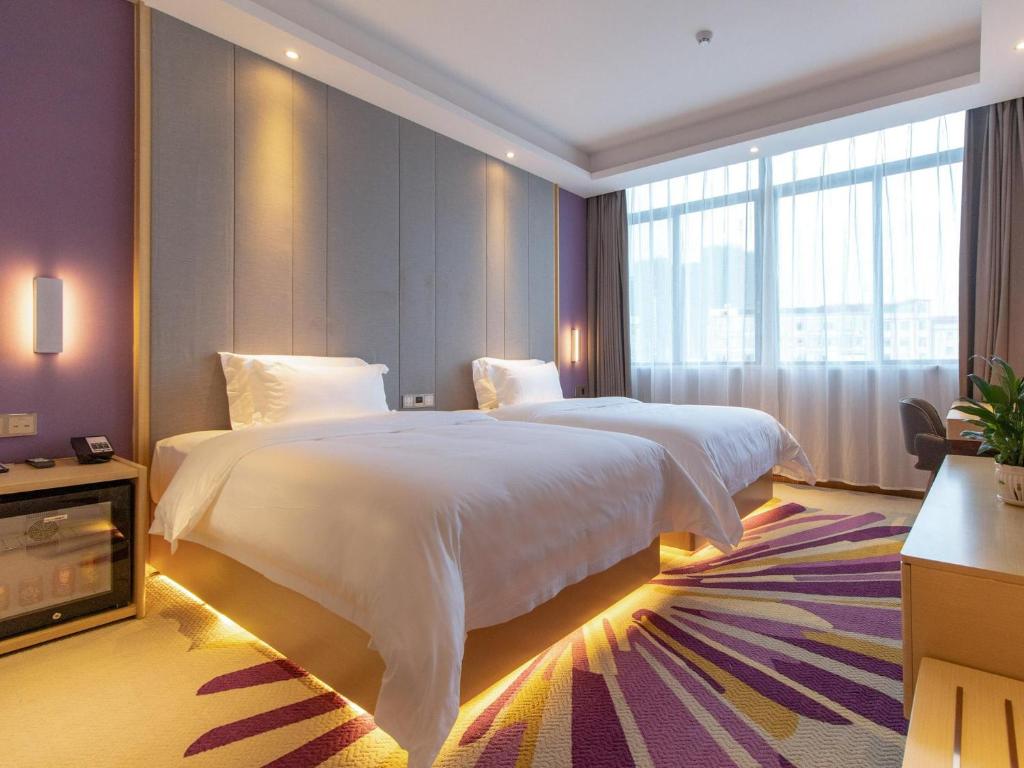 ein Schlafzimmer mit einem großen weißen Bett und einem großen Fenster in der Unterkunft Lavande Hotel Jiangmen Heshan Bus Terminal in Heshan