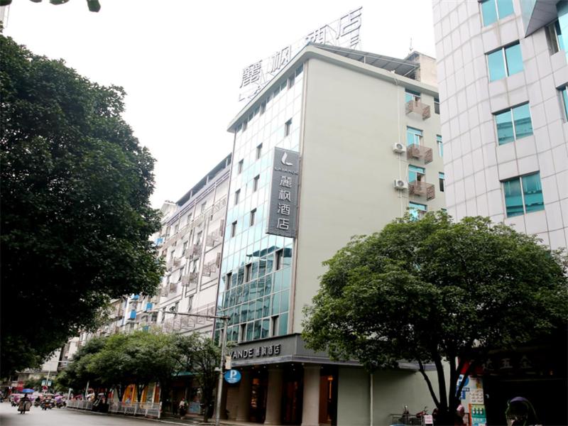 un gran edificio blanco en una calle de la ciudad con árboles en Lavande Hotel Guilin Longsheng, en Longsheng