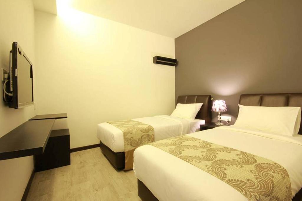 Postel nebo postele na pokoji v ubytování Sandy Hotel Malacca