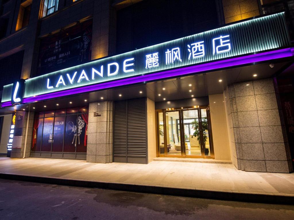 a building with a purple neon sign on it at Lavande Hotel Qijiang High-speed Railway Station in Qijiang