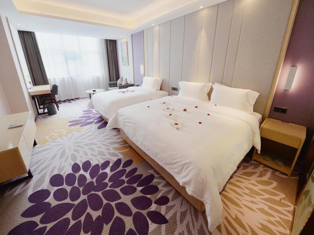 a hotel room with two beds with flowers on them at Lavande Hotel Xingyi Jushan Avenue in Xiawutun