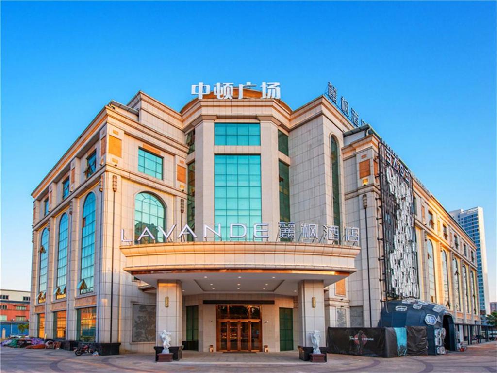 a large building with a sign on top of it at Lavande Hotel Jiangmen Golf Club in Jiangmen