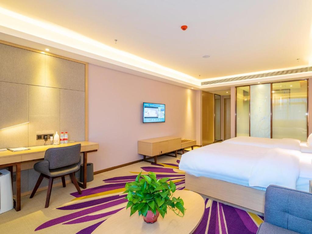 Cette chambre comprend un lit et un bureau. dans l'établissement Lavande Hotel Anshun West High-speed Rrailway Station, à Anshun