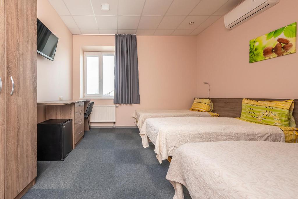 a hospital room with three beds and a tv at Air Kaunas in Karmėlava