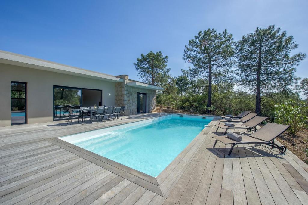 einen Pool mit Liegestühlen und ein Haus in der Unterkunft Maison Del Onda in Lecci