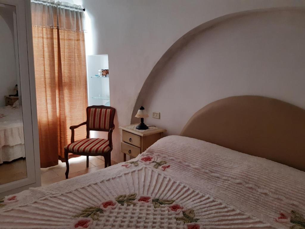 ファザーノにあるappartamento butterflyのベッドルーム1室(ベッド1台、椅子、窓付)