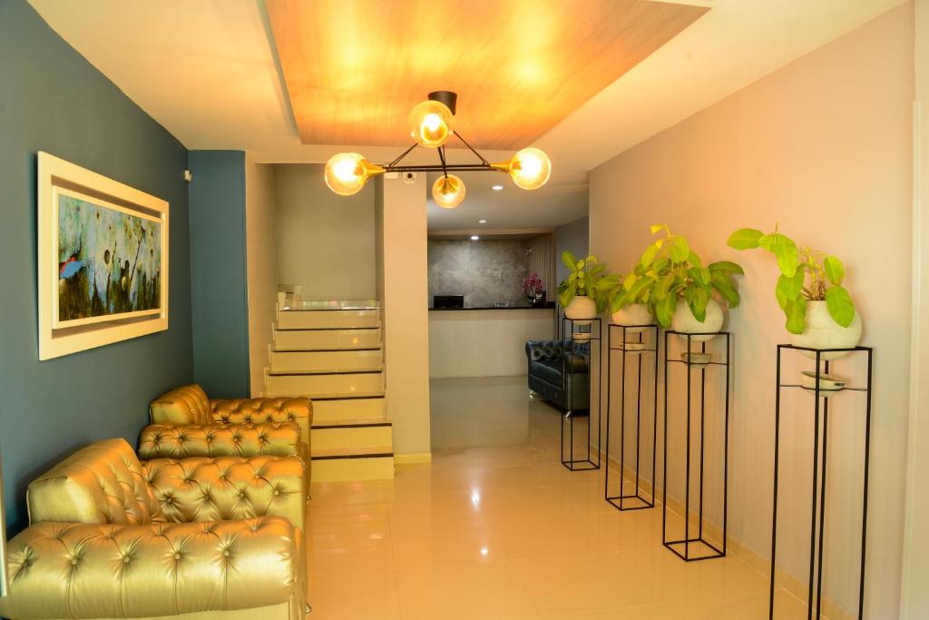 a living room with a couch and some plants at Hotel Quinta de Cabecera in Bucaramanga