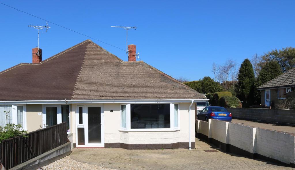 uma casa branca com um telhado castanho em Goldcrest Cottage em Sandown