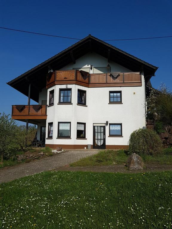 ein großes weißes Haus mit Holzdach in der Unterkunft Ferienwohnung Familie Weber in Losheim