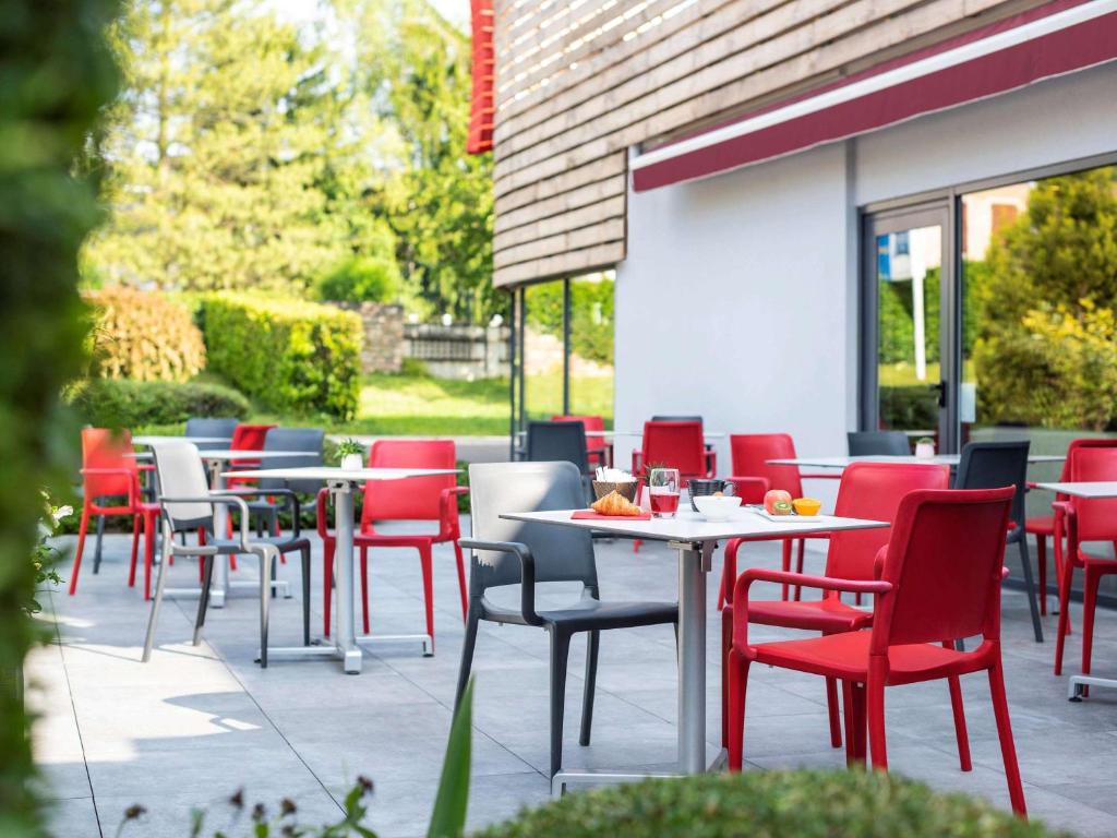 eine Gruppe von Tischen und Stühlen auf einer Terrasse in der Unterkunft ibis Nuits Saint Georges in Nuits-Saint-Georges