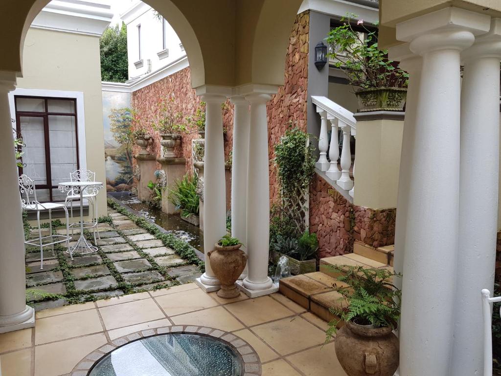 a house with a courtyard with potted plants at Villa Lugano Guesthouse in Johannesburg