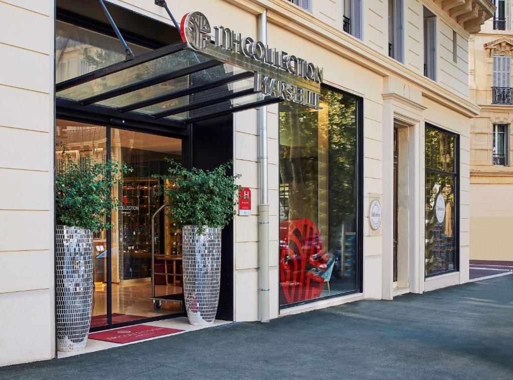 a store front with two large vases in front of it at NH Collection Marseille in Marseille