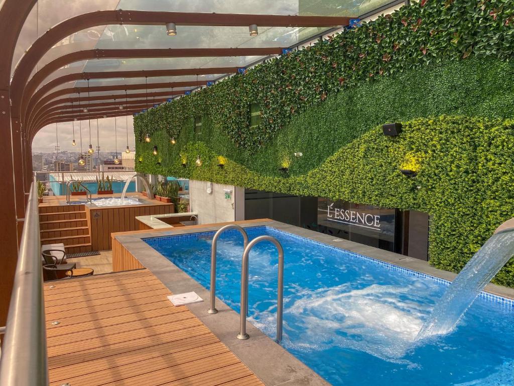 a swimming pool with a wall of ivy at Mercure Alameda Quito in Quito