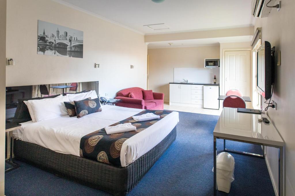 a hotel room with a bed, desk and a television at Best Western Mill Park Motor Inn in Morang