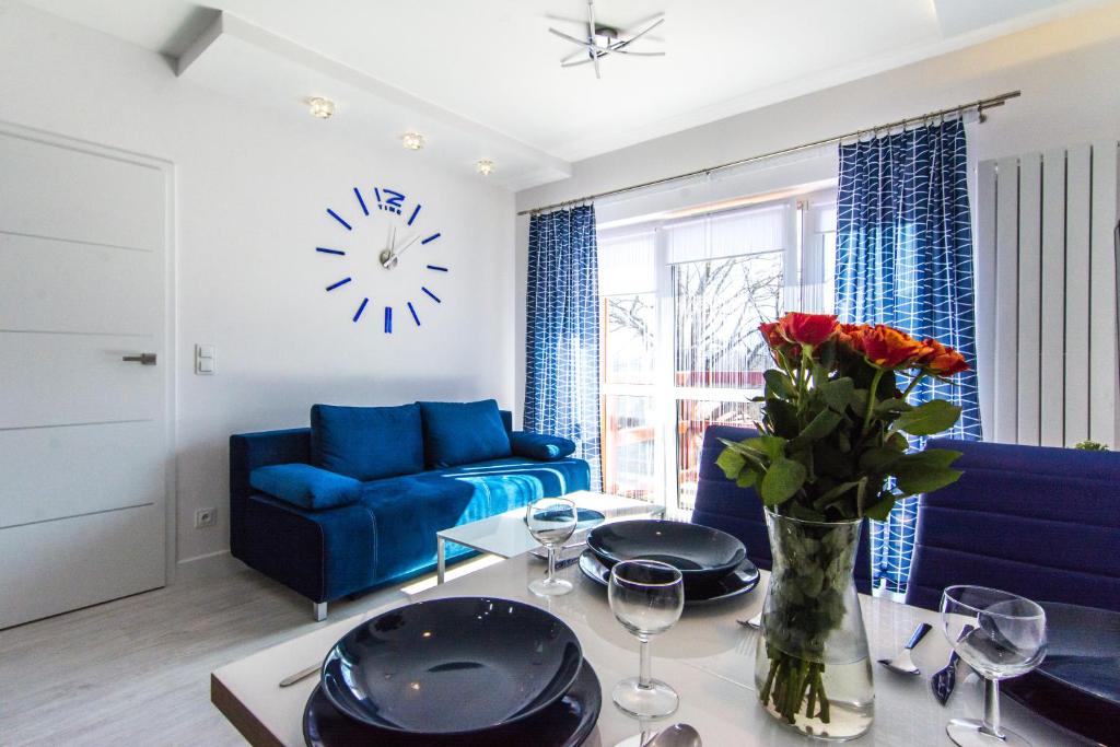 a living room with a blue couch and a table with flowers at Apartamenty Izerskie - ul. Sienkiewicza 9 in Świeradów-Zdrój