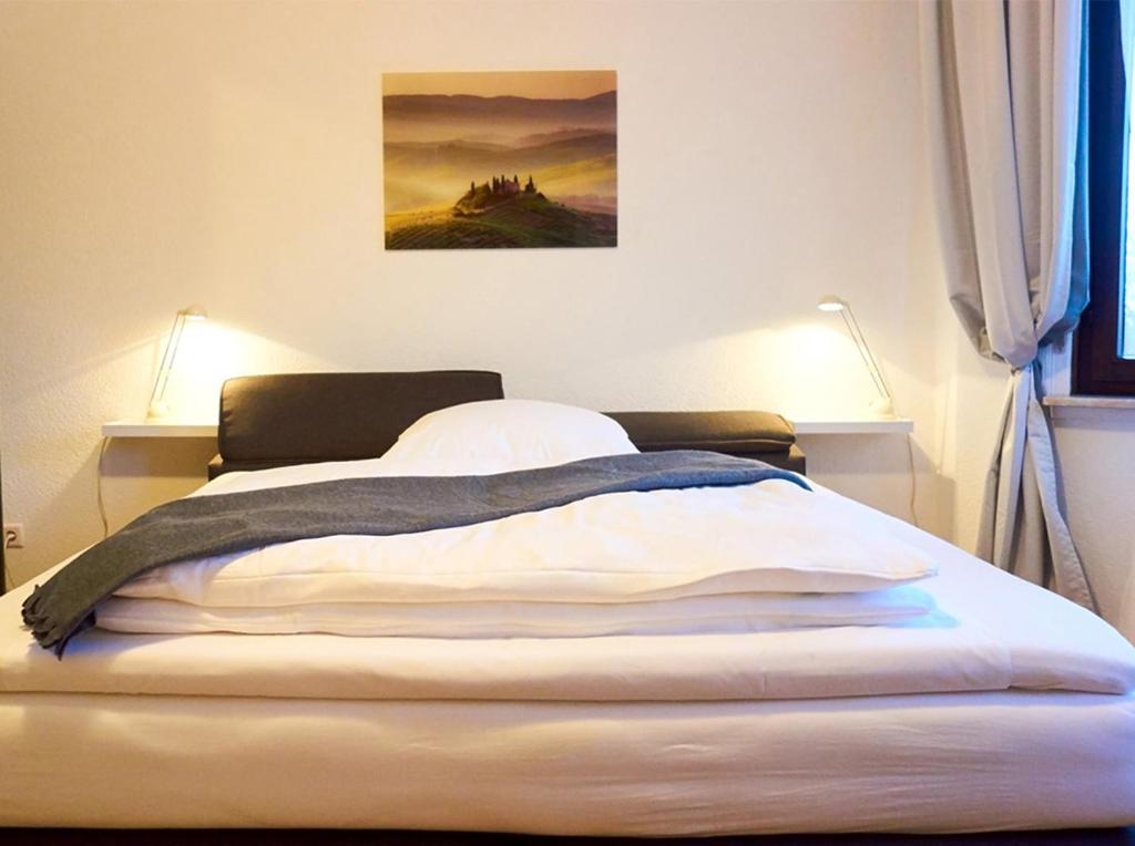 Apartments Ho30 في شتوتغارت: سرير في غرفة نوم مع لوحة على الحائط