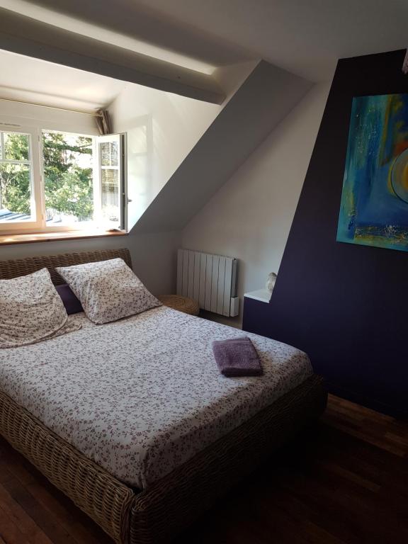 1 dormitorio con 1 cama y una pintura en la pared en 18 châteaux et Beauval sur un rayon de 30 km, en Saint-Georges-sur-Cher