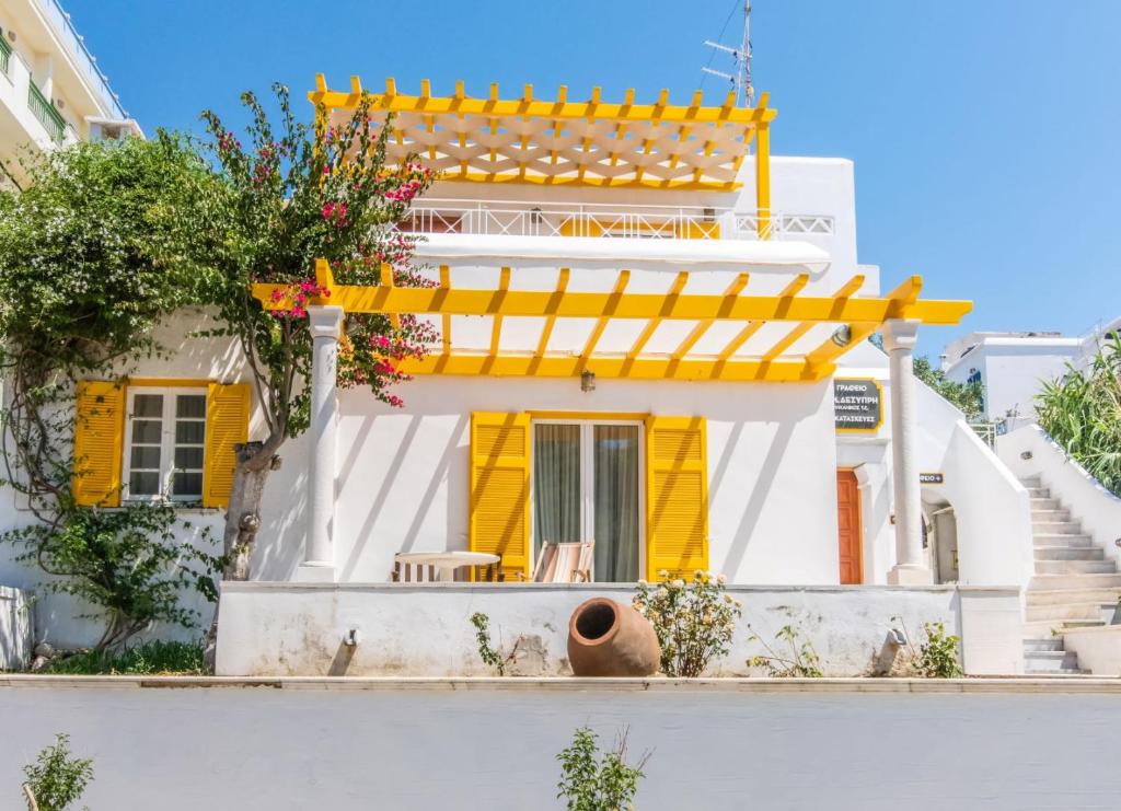 una casa gialla e bianca con scala gialla di Estia Tinos a Città di Tinos