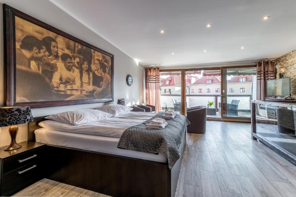 a bedroom with a bed with a large painting on the wall at Apartamenty K2 Podmurna 36 in Toruń