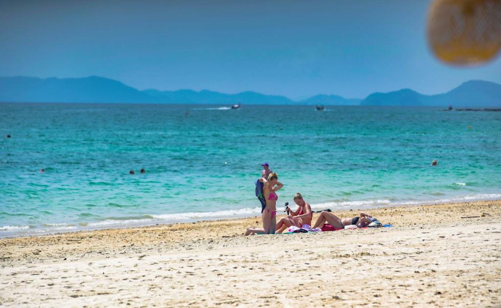 a group of people laying on the beach at Anyavee Krabi Beach Resort formerly known as Bann Chom Le Beach Resort in Klong Muang Beach