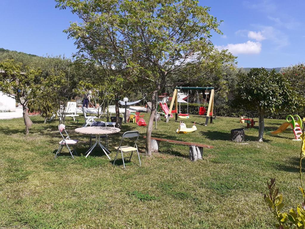 a park with a table and chairs and a playground at agriturismo heaven in Capo Vaticano