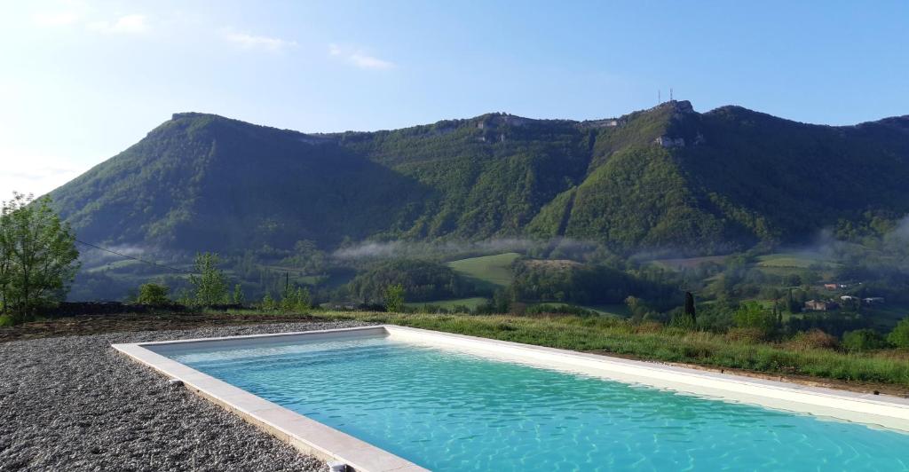 une piscine avec une montagne en arrière-plan dans l'établissement L ' AMIRADOU, à Félines-sur-Rimandoule