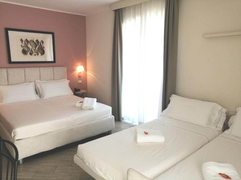 a hotel room with two beds and a window at Hotel San Pietro Palace in Finale Ligure