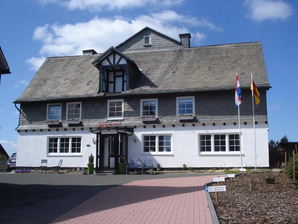 a large white building with flags in front of it at B&B All Seasons in Winterberg