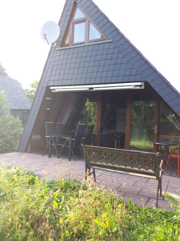 a bench in front of a building with a roof at Feriendorf Freilingen 151 A in Blankenheim