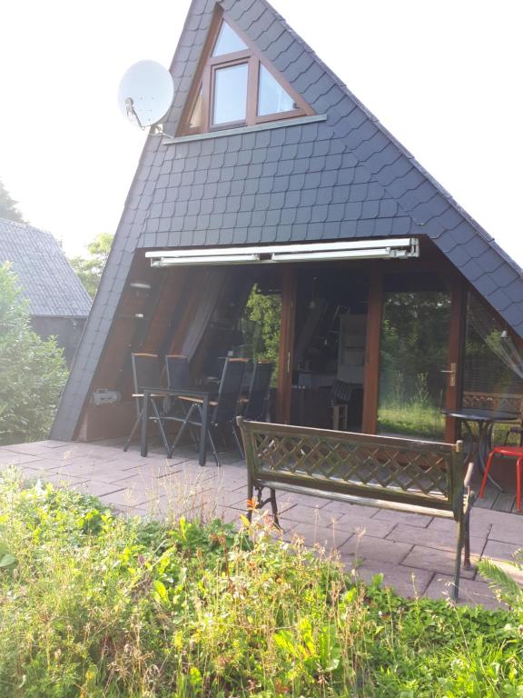 eine Bank vor einem Gebäude mit einem Dach in der Unterkunft Feriendorf Freilingen 151 A in Blankenheim