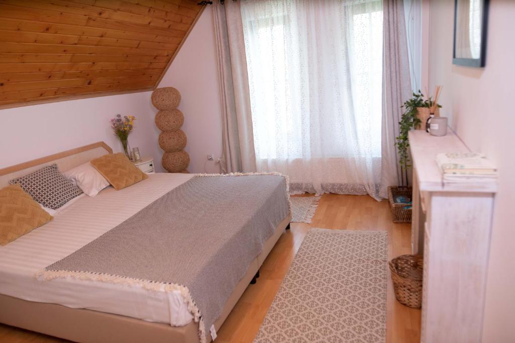 Un dormitorio con una cama grande y una ventana en Marie Chalet, en Breaza