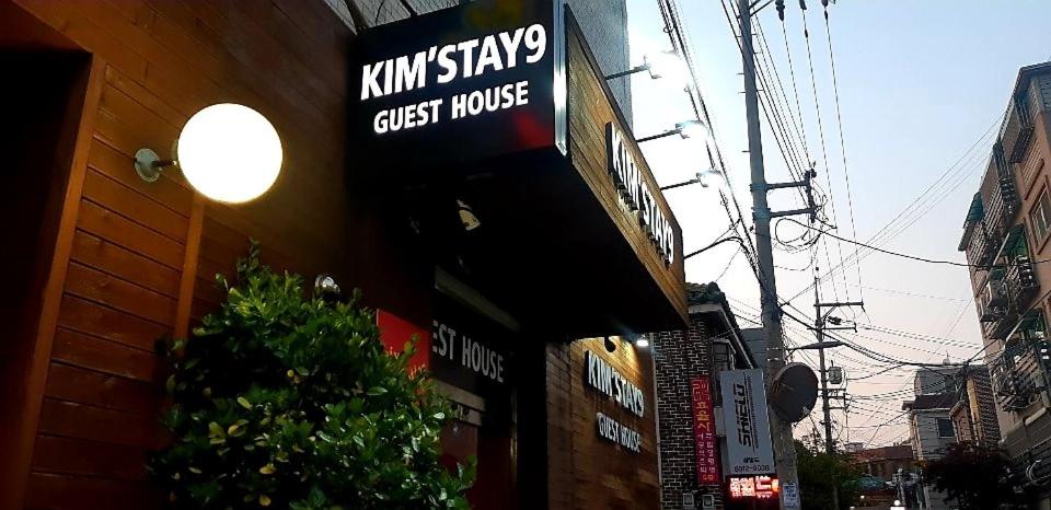 un letrero para una casa de huéspedes al lado de un edificio en Kimstay 9, en Seúl