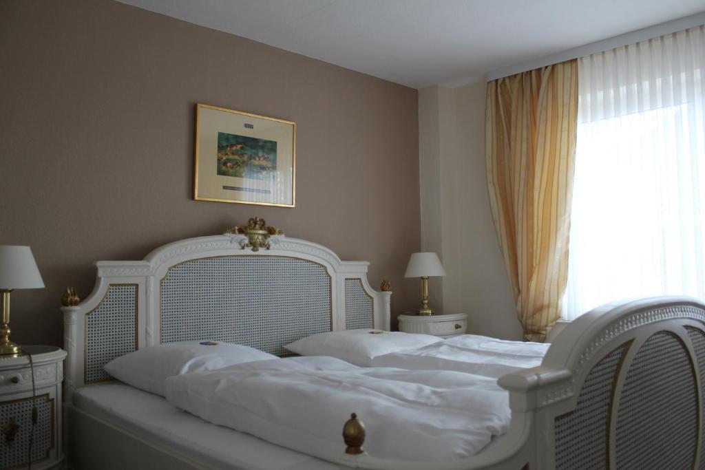 two white beds in a bedroom with a window at Elbhotel Bleckede in Bleckede