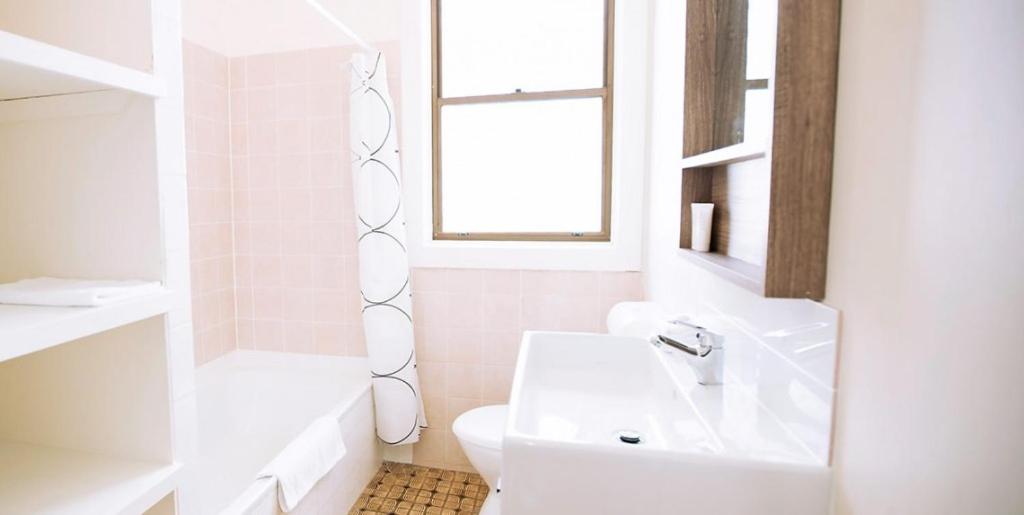 bagno con lavandino, servizi igienici e finestra di Hibiscus Motel a Byron Bay
