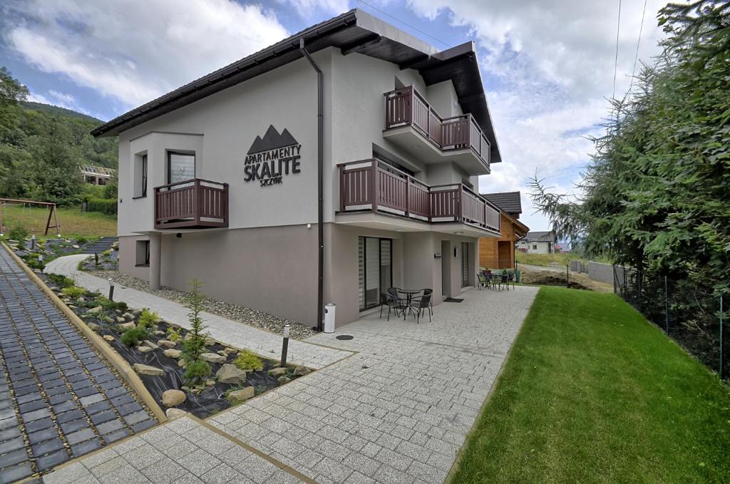 a building with balconies on the side of it at Apartamenty Skalite Szczyrk ul Woźna 14 in Szczyrk