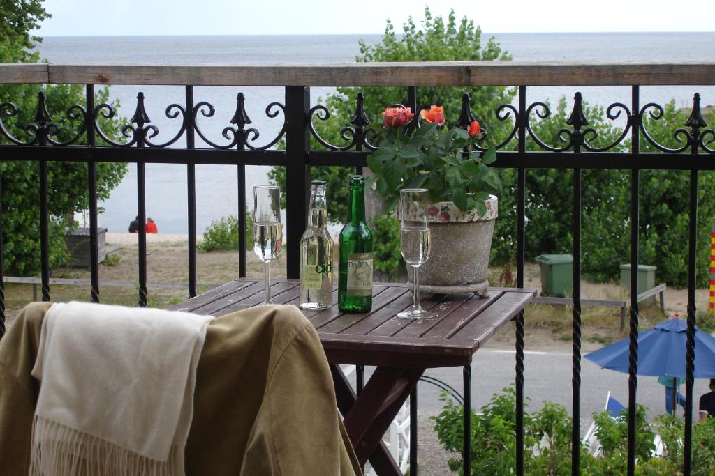 a wooden table with wine glasses and flowers on a fence at STF Kivikstrand Badhotell in Kivik
