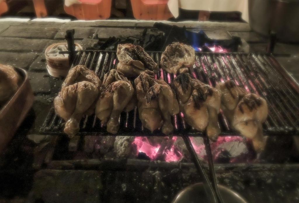 a bunch of meat cooking on a grill at Hôtel Le Sherpa Val Thorens in Val Thorens