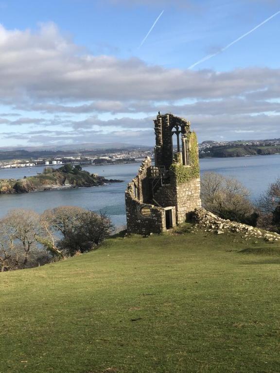 an old building on a hill next to a body of water at Manor Lodge Guesthouse in Millbrook