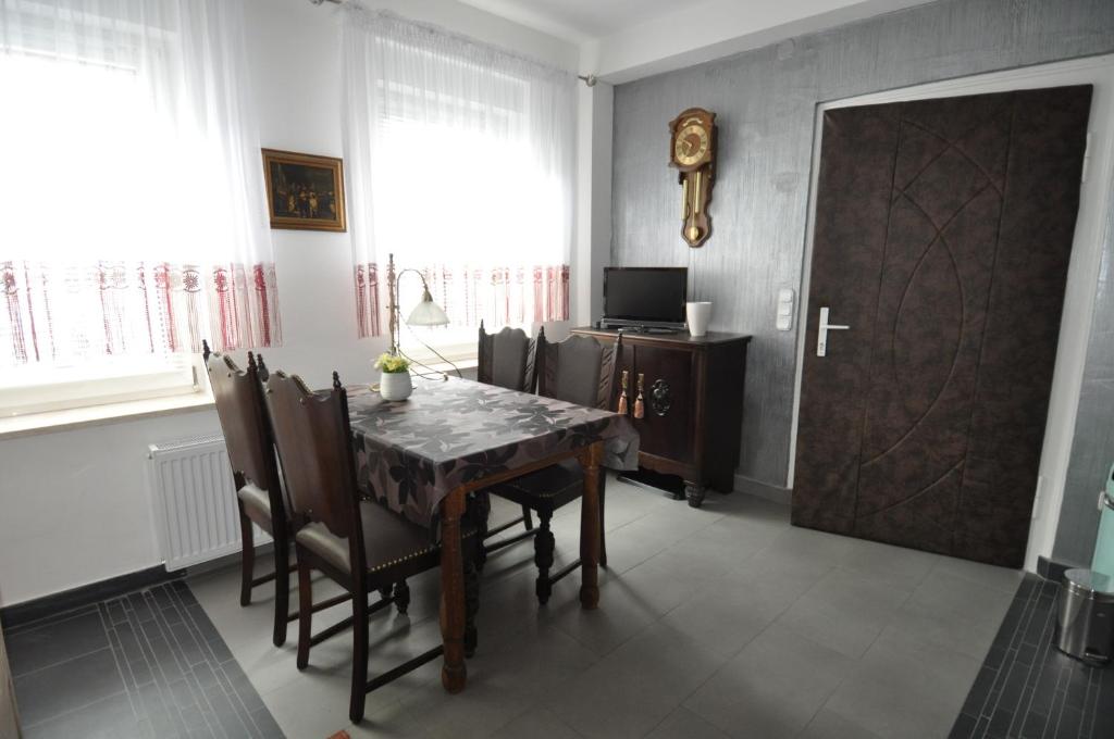 a dining room with a table and chairs and a door at Ferienwohnung Kuckucksnest in Helmstedt