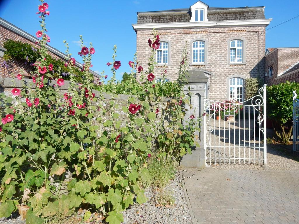 a gate in front of a house with red roses at Le Chant du coucou in Huy
