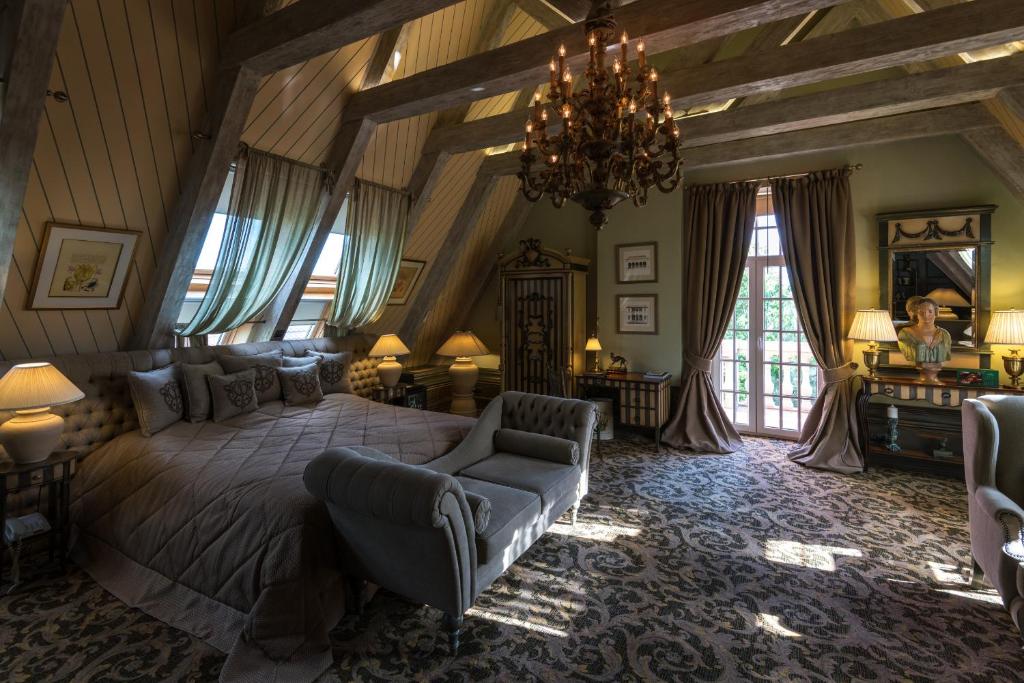 Un dormitorio con una cama grande y una lámpara de araña. en Hotel Old House Resort & SPA, en Ust'-Koysug