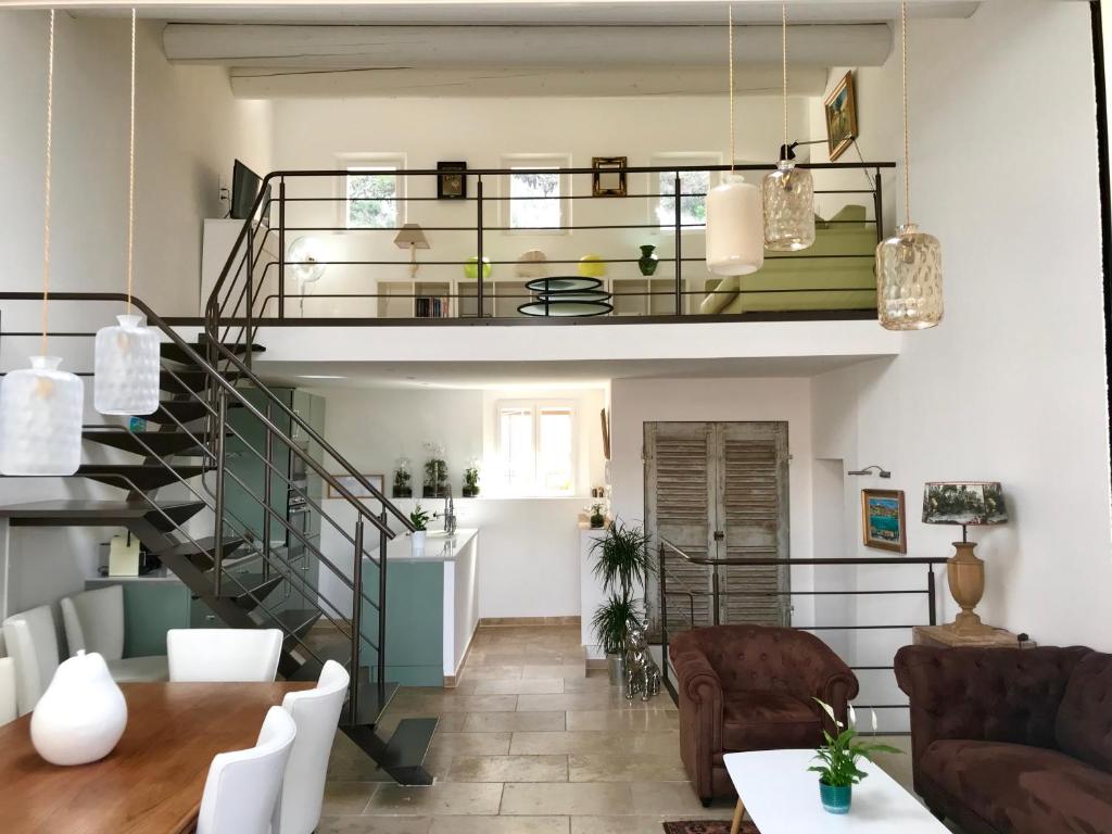 a living room with a spiral staircase and a table at La Maison du Courtil, Amande-Olive in Moustiers-Sainte-Marie