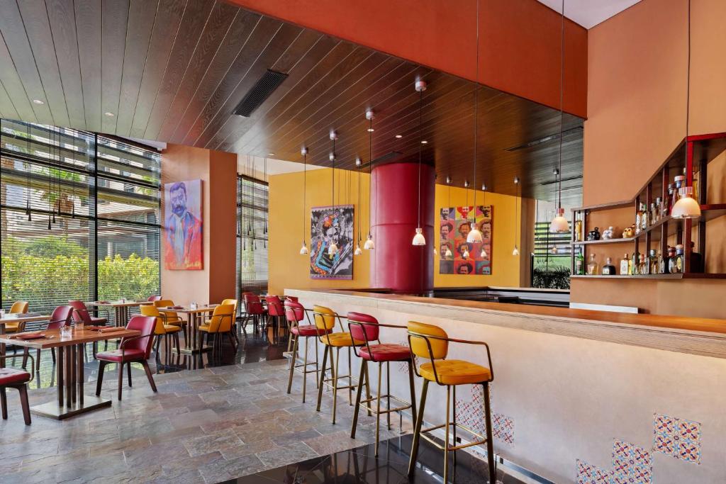 a restaurant with a bar with chairs and tables at Park Inn by Radisson Abu Dhabi Yas Island in Abu Dhabi