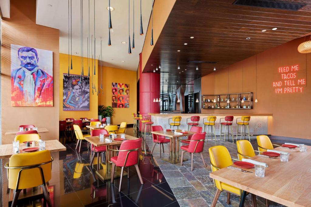 a restaurant with yellow and red chairs and tables at Park Inn by Radisson Abu Dhabi Yas Island in Abu Dhabi